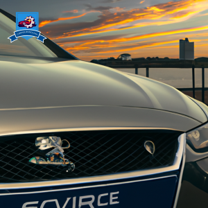 An image of a sleek, modern car parked in front of the Suffolk skyline at sunset