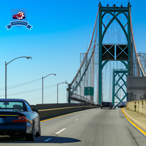 image of a car driving through the iconic Claiborne Pell Newport Bridge in Portsmouth, Rhode Island, with a clear blue sky in the background to represent the affordability of car insurance in the area